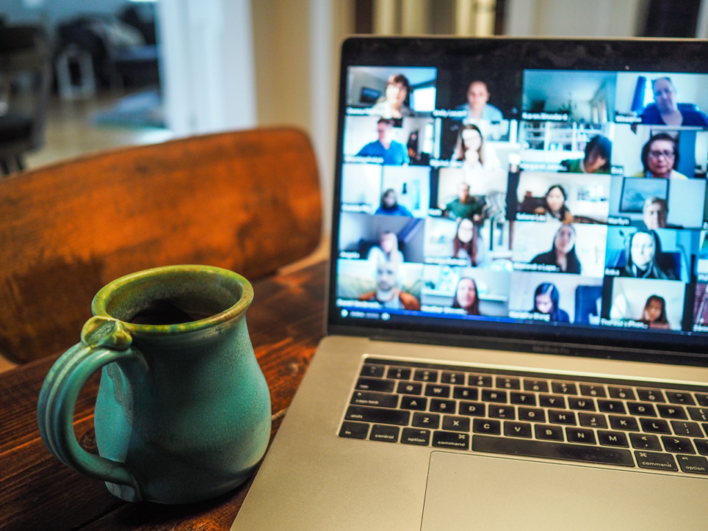 virtual meeting on laptop with coffee cup in foreground